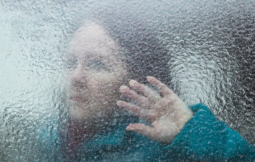 Mulher com a mão no vidro sofrendo de transtorno de ansiedade