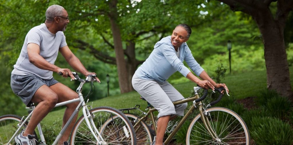 homem e mulher de meia idade andando de bicicleta no parque
