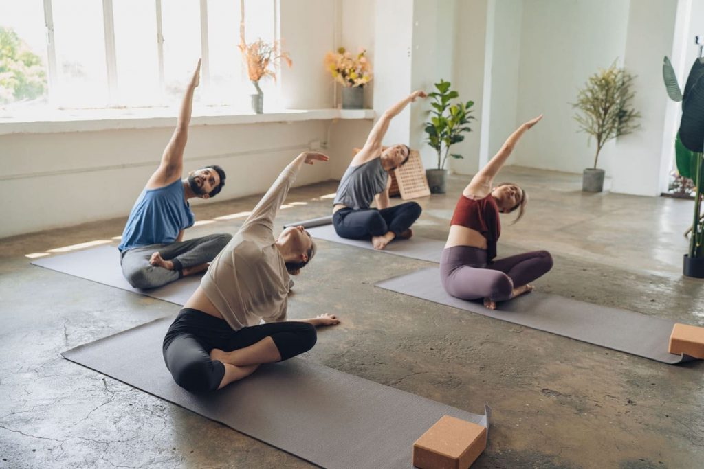 grupo de pessoas fazendo uma aula de yoga em um estúdio